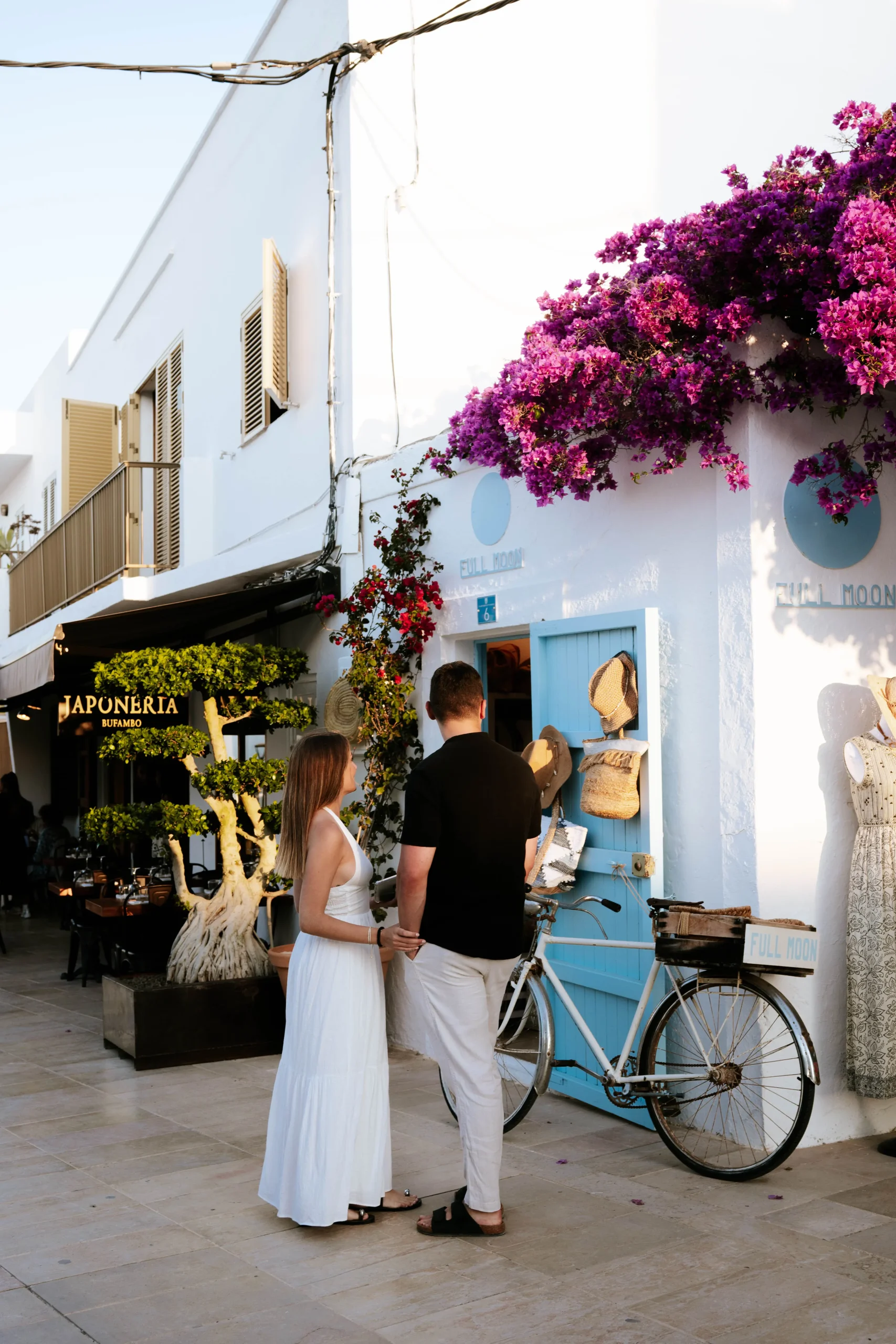 Couple walking by shops and boutiques in San Francesc, Formentera